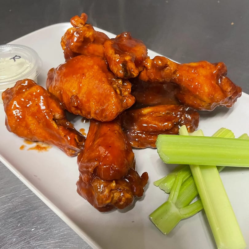 TopCrust Jupiter Kitchen's buffalo wings, with celery sticks and a side of ranch dressing.